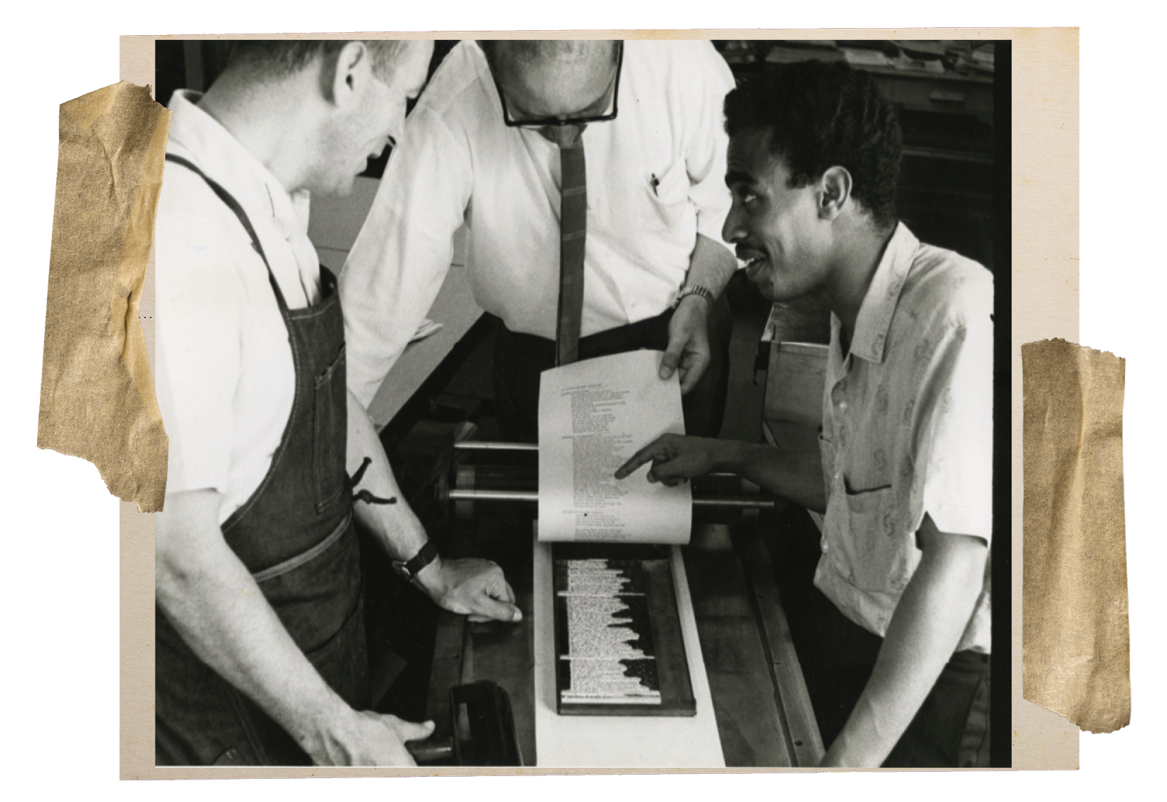 Three men in white shirts gathered around a print press.