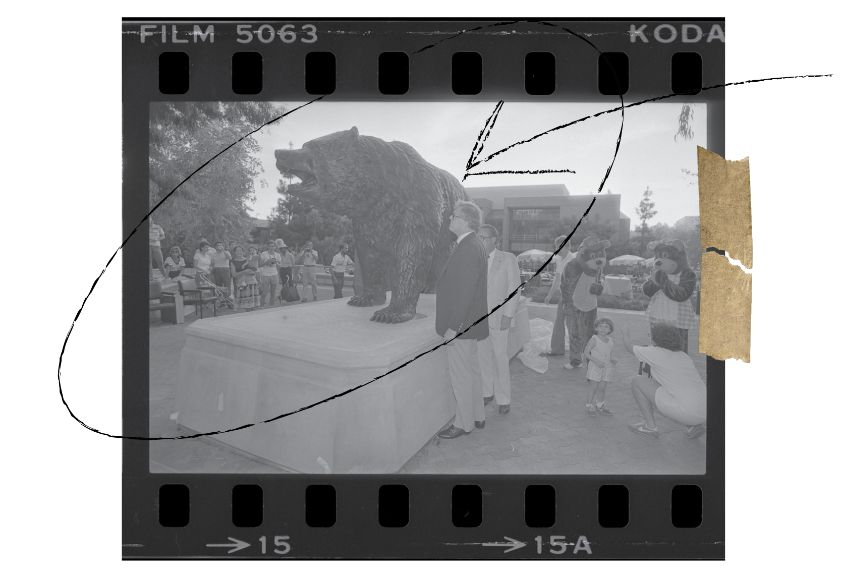 A black and white photograph of Charles E. Young, onlookers, and two people in bear costumes.