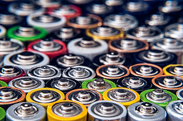 The tops of an array of colorful disposable batteries