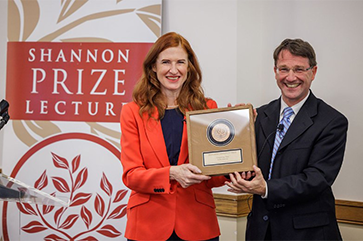Stella Ghervas, left, in a red jacket, receives an award from Clemens Sedmak