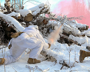 Nam Yong Chu in white combat outfit in wilderness and snow shooting off rocket