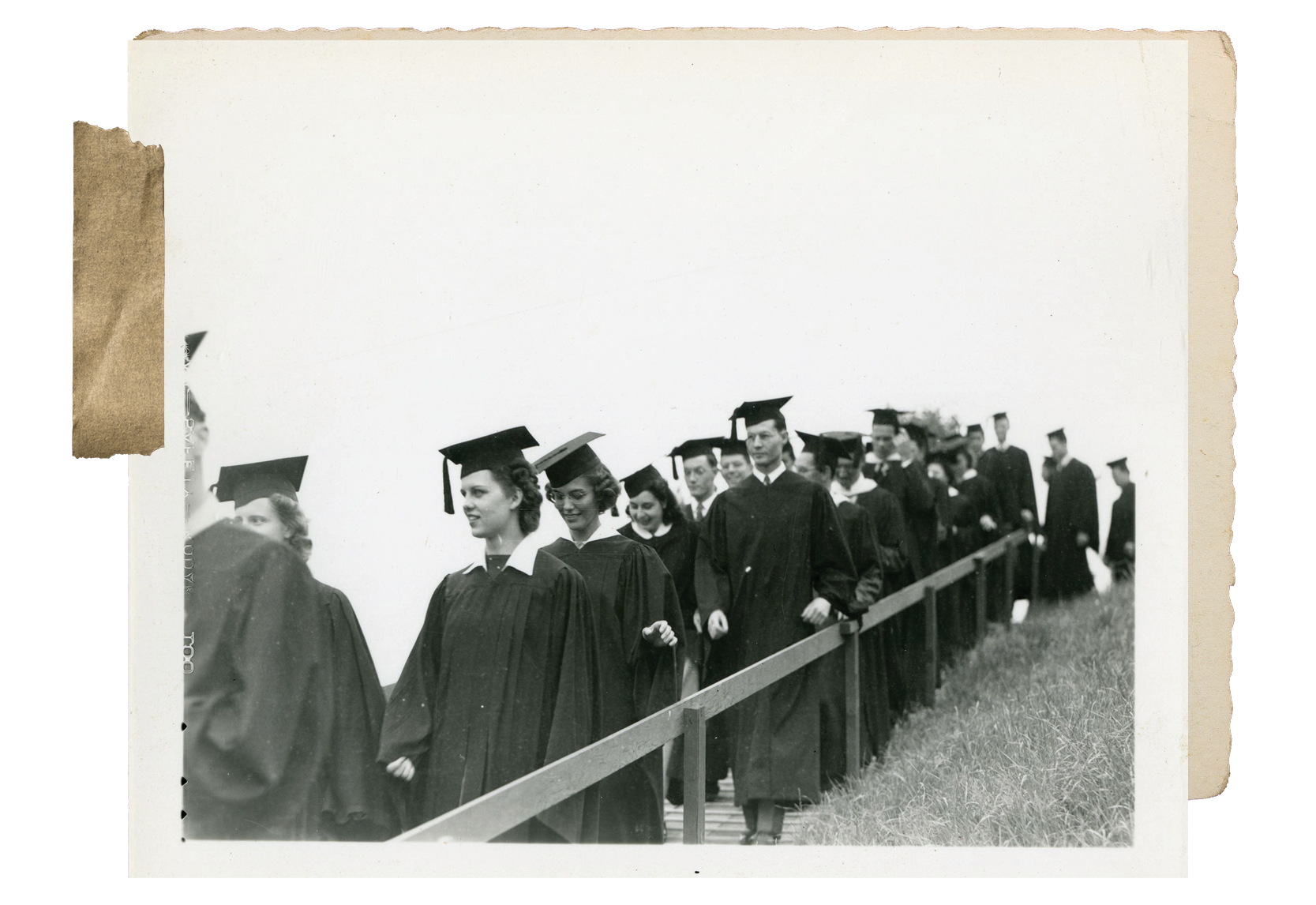 A black and white photograph of students in caps and gowns, likely attending the first commencement held on the Westwood campus on June 14, 1941.