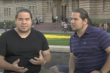 Caleb Dunlap in black shirt (left) and his brother, Jared Dunlap, in dark striped shirt with Powell Library in background