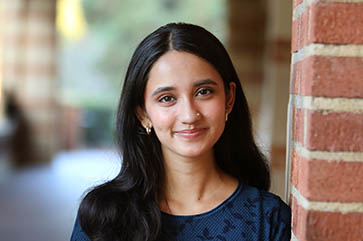 Arushi Avachat in a dark blue patterned top standing in Royce Hall Portico