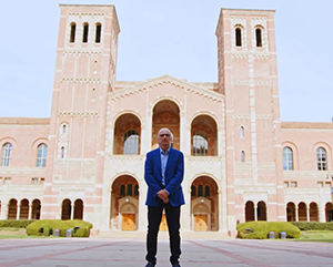 Robert Gurval standing with arms crossed in front of Royce Hall