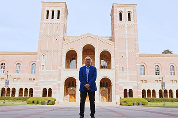 Robert Gurval standing with arms crossed in front of Royce Hall