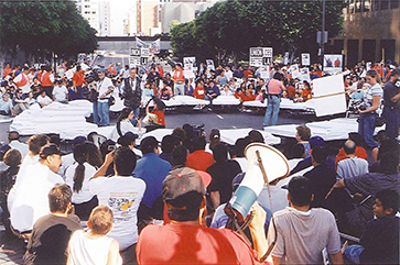 A group of union protesters with signs in the middle of a Los Angeles street