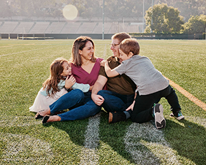 Michelle and Jamie Strohiro, with their children Zoe and Jordan, photographed on the 50-yard line on the intramural field.