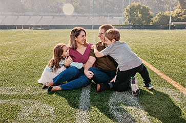 Michelle and Jamie Strohiro, with their children Zoe and Jordan, photographed on the 50-yard line on the intramural field.