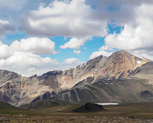 White Mountain on a sunny day with white clouds populating a blue sky.