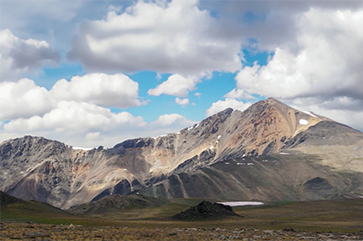 White Mountain on a sunny day with white clouds populating a blue sky.