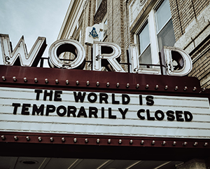 Theater marquee reads “The world is temporarily closed”