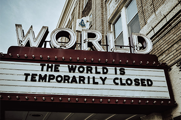 Theater marquee reads “The world is temporarily closed”