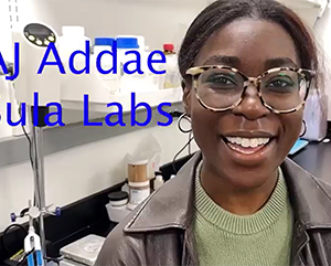 AJ Addae wearing a green sweater and a black leather jacket in a lab setting.