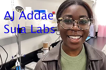 AJ Addae wearing a green sweater and a black leather jacket in a lab setting.