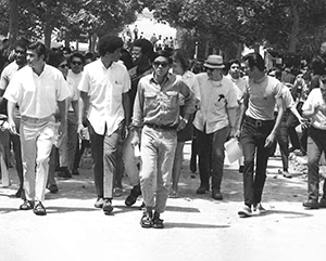 Black-and-white photo of Morgan Chu (front) marching with other students at UCLA in the 1960s