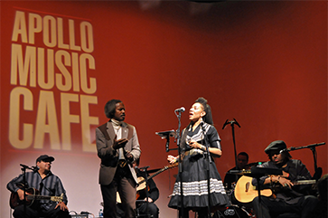 Martha Redbone singing on stage in a black dress