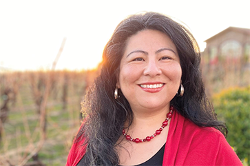 Head-and-shoulders photo of Claudia Salcedo with red necklace and top