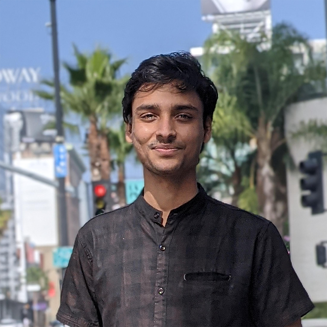 A photograph of Aditya Dash standing in an urban setting. 