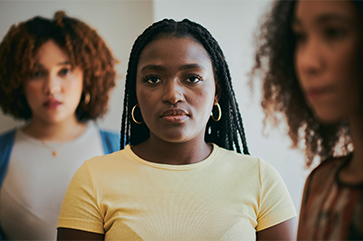 three young women looking wearing a look of concern on their faces.