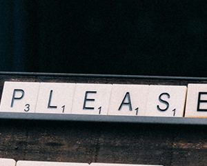 Scrabble-like tiles spell out the word “please.”