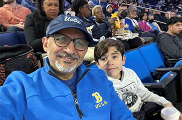 Alumnus Ihab Shahawi with his grandson at a UCLA basketball game.