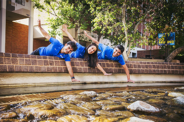 Bruin tour guides Marcus Aurelius, Sierra Benayon-Abraham and Sanketh Santhosh smiling — but not touching! — at the famed Inverted Fountain