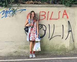 Elya+profile-363-241 Elya Aboutboul-Bilia stands against a concrete wall.