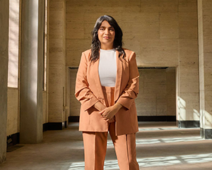 SabaWaheed_363-241 Saba Waheed at the historic Trust Building, the site of her office in the new UCLA Downtown campus, wearing a salmon colored suit.