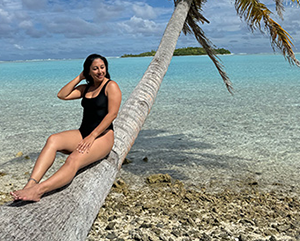 kalena+mcelroy_363-241 McElroy striking a pose in Hawaii as she sits on a palm tree that hangs over clear waters.