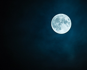 moon-363-241 A full moon against a black night sky with some faint clouds.