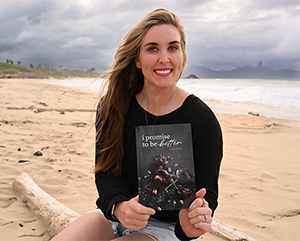 Erinn-K-363-241 Erinn Keala holding a copy of her book on the beach.