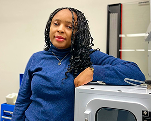 A-K-363-241 Professor Alvine Kamaha standing in front of instrumentation in her laboratory