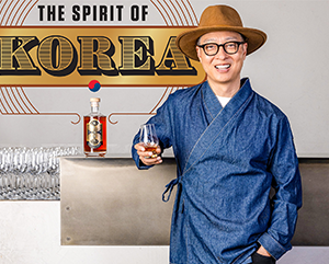 Do-363-241 Bryan Do leaning against a bar top with an illustration in the background that reads: The Spirit of Korea.