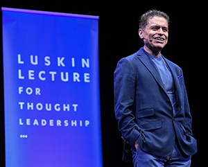 FZ-LLFTL-363-241 Fareed Zakaria on stage in blue jacket with “Luskin Lecture for Thought Leadership” in background