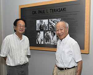 Terasaki-story-363-241 Mark Terasaki (left) and Richard Terasaki standing in front of a large plaque dedicated to the late Dr. Paul I. Terasaki.