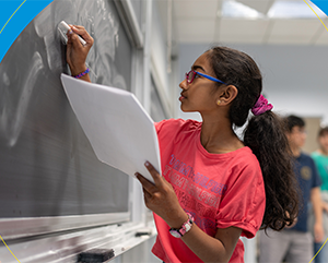 math-circle-363-241 A young female student drawing math equations on a chalk board.