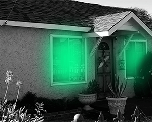 paranormal-activity-363-241 A black and white photo of a house with green light emanating from the windows.