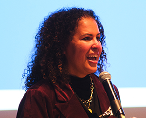 Noble+ceremony-363-241 Safiya Noble speaks into a microphone at her installation ceremony as the David O. Sears Presidential Chair in Social Sciences.