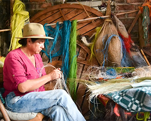 Colombian-Plants-Article_Hero-363-241 Angelina Sanchez Bustacara in jeans and a pink shirt weaving baskets in Boyacá, Colombia.