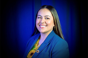 Head-and-shoulders photo of Arlene Cano Matute in blue jacket and floral-patterned top