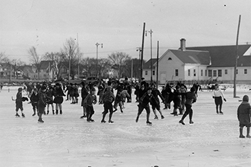 Kids ice skating outdoors on frozen grounds