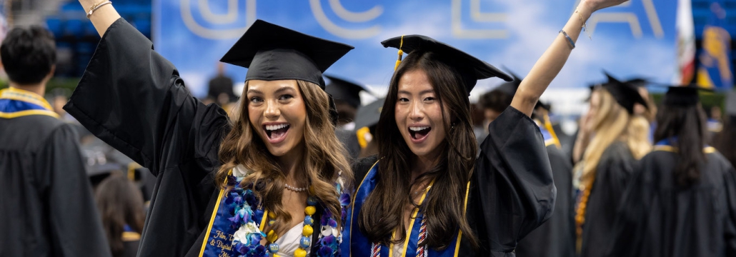 Two newly minted graduates pose for the camera