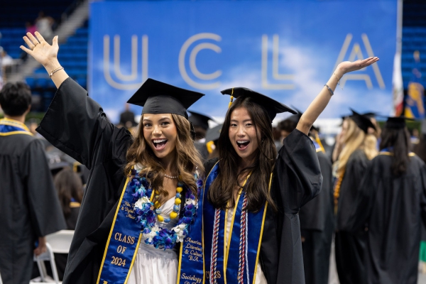 Two newly minted graduates pose for the camera