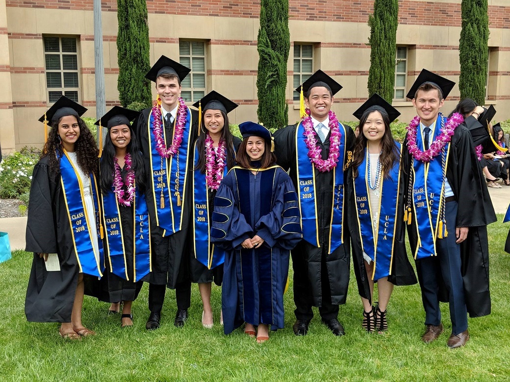 Linda Zanontian standing with the 2018 DataFest student committee members, all smiling and dressed in commencement regalia