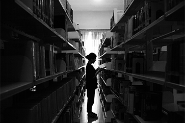 A student in the stacks of a library