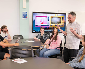 Danny-Snelson-teaching-by-Stephanie-Yantz-363-241 Danny Snelson, standing, center right, with four students seated in classroom