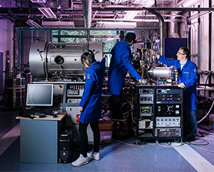 UCOP-Research-363-241 Scientists in blue coats working with machinery in a lab