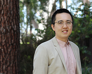 Eric Min outdoors in peach button-down and beige jacket