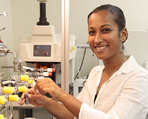 Aradhna-Tripati-photo-363-241 Aradhna Tripati in a white shirt, smiling inside of a lab setting.